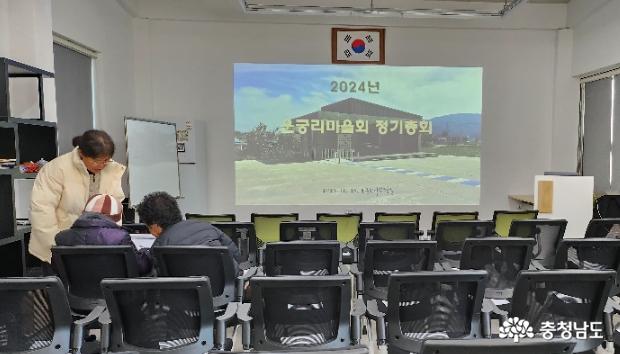 회의 진행 전에 총무님이 참석자들께 본인 서명을 받는 등록 절차를 밟고 계십니다.